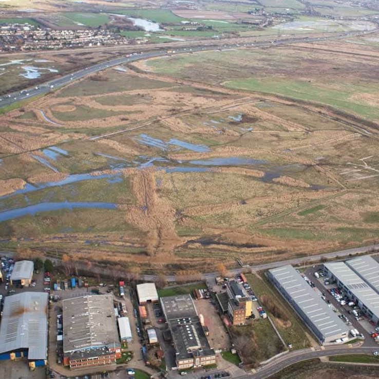 Aerial view of restored wetlands, a mix of wet grassland, reedbeds and open water, with the new public access paths